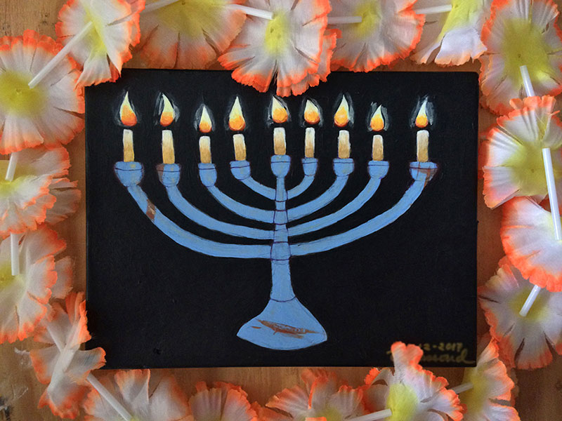 Blue menorah against black, surrounded by a flower lei.