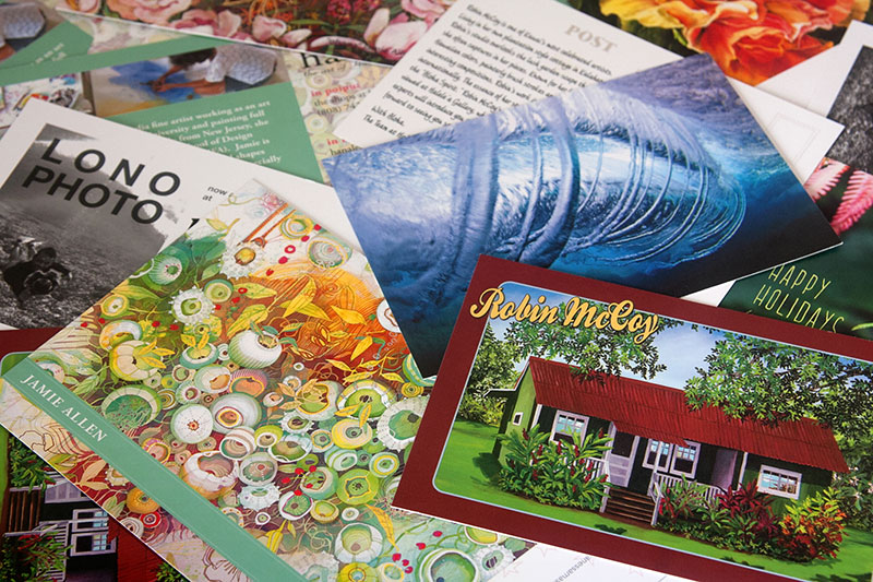 Numerous colorful postcards in random arrangement.
