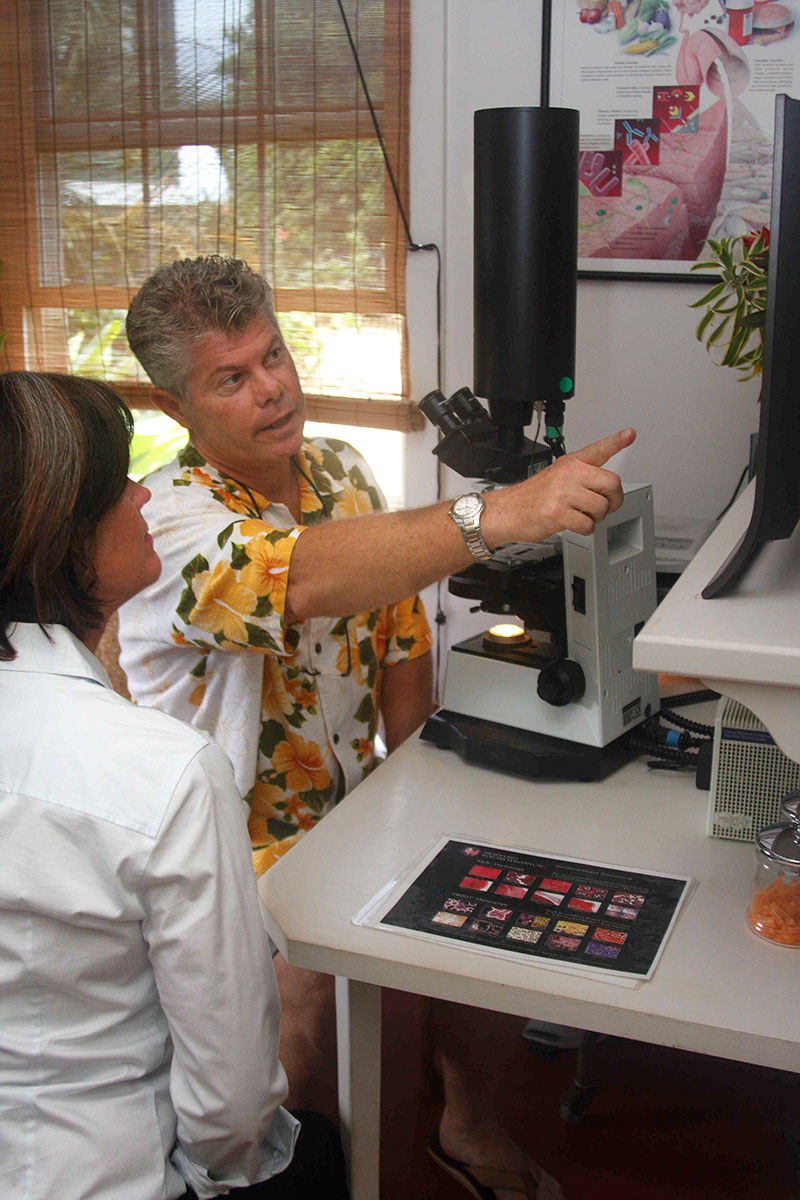 Man sitting at large microsope with patient.